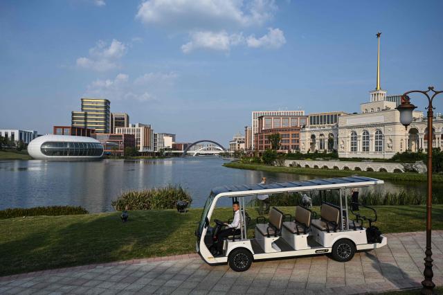 A shuttle bus drives past a lake at Huawei Lianqiu Lake research campus during a media tour in Shanghai on September 16, 2026. (Photo by Jade GAO / AFP)