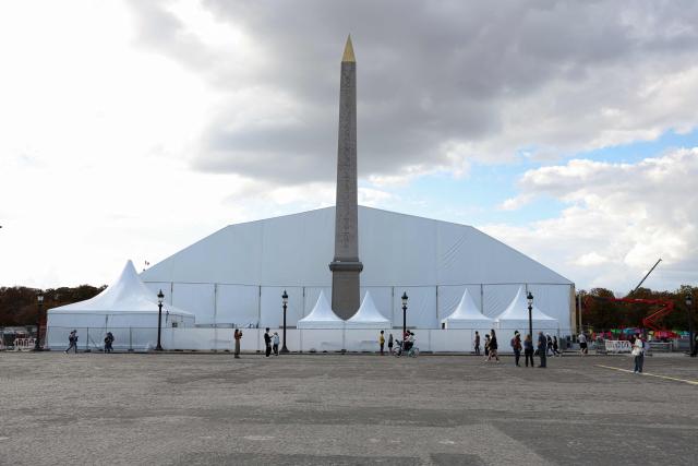Pedestrians walk past a grandstand under construction ahead of the visit of Pope Leo XIV to France, with the Obelisk in the foreground, at Place de la Concorde in Paris on September 16, 2026. (Photo by Charlotte SIEMON / AFP)