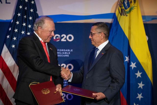 (L/R) Harold Hamm, chairman of  Continental Resources, shakes hands with PDVSA Executive Vice President Jovanny Martinez after signing an agreement during the third day of the G20 Ministerial Meeting on Energy Abundance in Houston, Texas on September 16, 2026. The discussions are slated to run through September 16 in Houston, in the oil-rich US state of Texas. The meetings gather delegations from the world's largest economies -- including China, India, Japan and Germany -- with major oil producers set to attend, such as Canada and Saudi Arabia. (Photo by RONALDO SCHEMIDT / AFP)