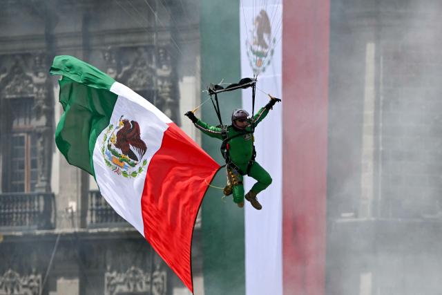 A parachute jumper waves a Mexican flag during the Independence Day military parade at the Zocalo square in Mexico City on September 16, 2026. (Photo by Yuri CORTEZ / AFP)