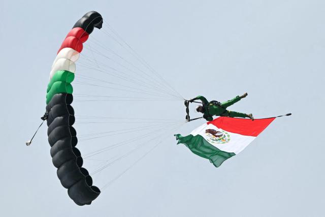 A parachute jumper waves a Mexican flag during the Independence Day military parade at the Zocalo square in Mexico City on September 16, 2026. (Photo by Yuri CORTEZ / AFP)