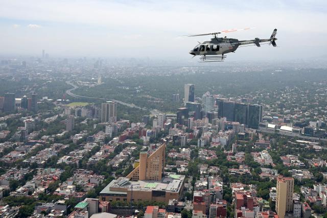A helicopter of the Mexican Air Force performs a flypast over Mexico City during the Independence Day military parade in Mexico City on September 16, 2026. (Photo by Alfredo ESTRELLA / AFP)