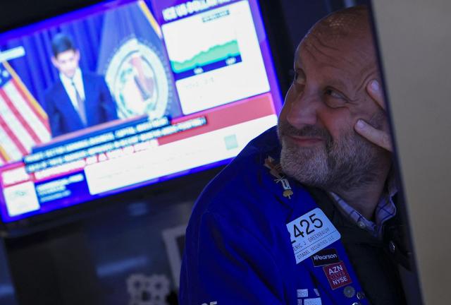 A trader looks on as US Federal Reserve Chair Kevin Warsh is displayed on a television screen on the floor of the New York Stock Exchange (NYSE) in New York on September 16, 2026. The US Federal Reserve raised interest rates by 25 basis points Wednesday, its first hike in three years as the central bank battles high inflation with a move sure to anger President Donald Trump. (Photo by TIMOTHY A. CLARY / AFP)