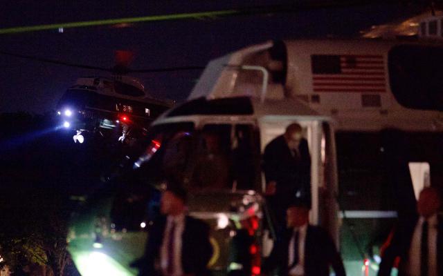 Personnel disembark from a support helicopter as Marine One, carrying US President Donald Trump arrives on the Ellipse near the White House in Washington, DC on September 16, 2026. Trump is returning from Gastonia, North Carolina after campaigning for Republican US Senate candidate Michael Whatley. (Photo by Kent Nishimura / AFP)