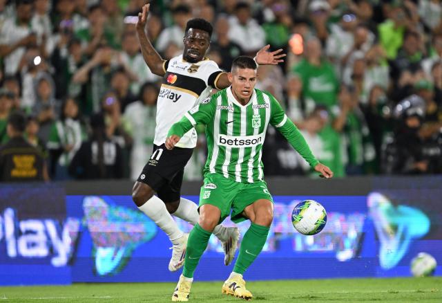 Atletico Nacional midfielder #23 James Rodriguez and Internacional de Bogota's forward #11 
Cristian Dajome fight for the ball during the Colombian first division football match between Internacional Bogota and Atletico Nacional at El Campin stadium in Bogota on September 16, 2026.. James will play for a Colombian football side after 18 years overseas. (Photo by Raul ARBOLEDA / AFP)