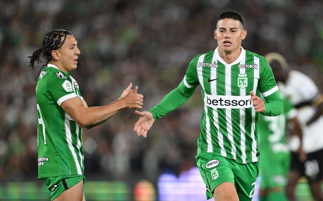 Atletico Nacional midfielder #23 James Rodriguez (R) greets teammate midfielder #99 Ian Poveda during the Colombian first division football match between Internacional Bogota and Atletico Nacional at El Campin stadium in Bogota on September 16, 2026. James will play for a Colombian football side after 18 years overseas. (Photo by Raul ARBOLEDA / AFP)