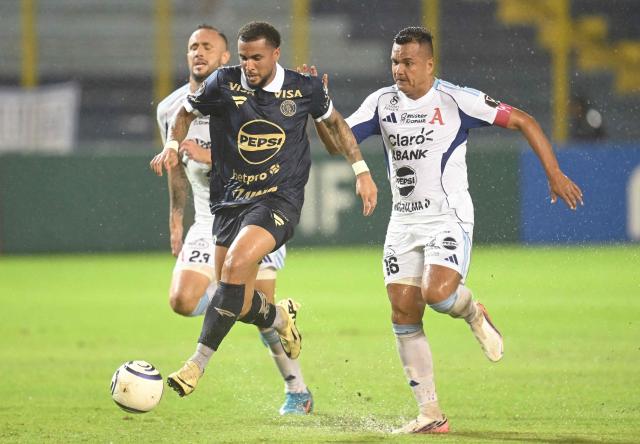 Motagua's Uruguayan forward #19 Rodrigo de Olivera evades Alianza's Argentine defender #23 Juan Monteagudo and midfielder #10 Leonardo Menjivar during the second-leg quarterfinal football match of the Concacaf Central American Cup between El Salvador's Alianza FC and Honduras' Motagua at the Cuscatlan Stadium in San Salvador on September 16, 2026. (Photo by MARVIN RECINOS / AFP)