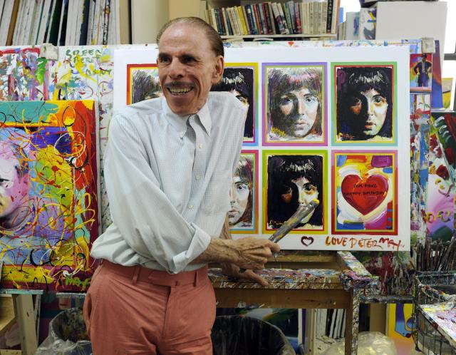 (FILES) Pop artist Peter Max poses in his New York studio on June 18, 2012 with seven portraits he created of Sir Paul McCartney to commemorate McCartney’s 70th birthday. American artist Peter Max, known in particular for designing the cover of the Beatles’ 1969 album “Yellow Submarine,” has died at the age of 88, his son announced on the US network ABC News on September 16. Born in 1937 in Berlin and forced to flee Nazi Germany with his family, Peter Max became in the 1960s an artist whose brightly colored, psychedelic-inspired works were distributed across a wide range of products. (Photo by Timothy A. CLARY / AFP)