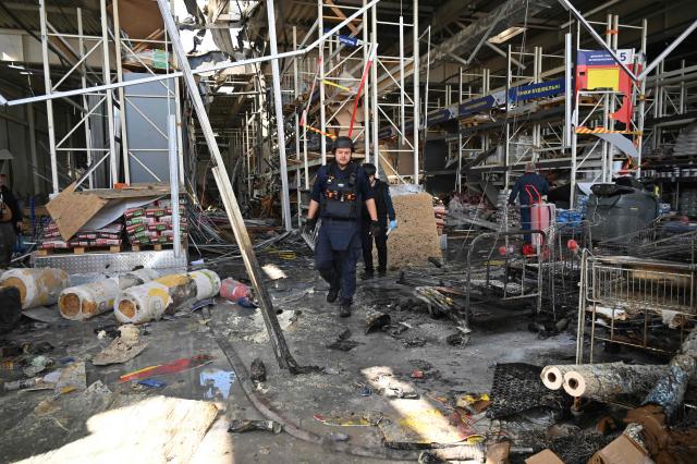 A police officer inspects damage at a shopping mall following an aerial strike in Kharkiv on September 17, 2026, amid Russia’s invasion of Ukraine. (Photo by SERGEY BOBOK / AFP)