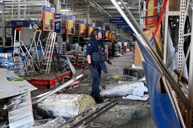A police officer inspects damage at a shopping mall following an aerial strike in Kharkiv on September 17, 2026, amid Russia’s invasion of Ukraine. (Photo by SERGEY BOBOK / AFP)