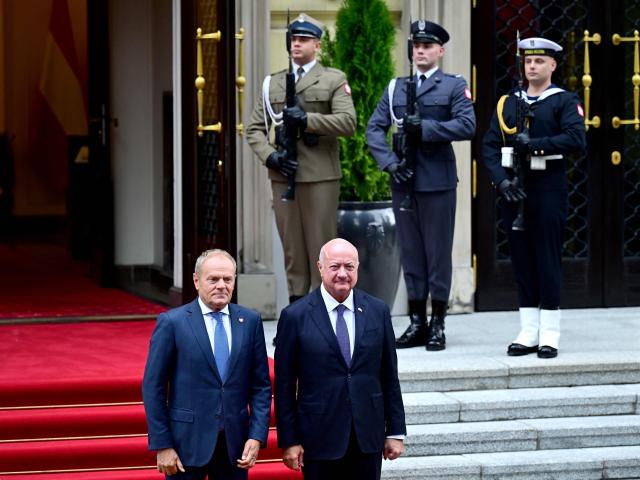 Polish Prime Minister Donald Tusk (L) receives Austrian Chancellor Christian Stocker with military honours for a meeting in Warsaw on September 17, 2026. (Photo by ROLAND SCHLAGER / APA / AFP) / Austria OUT