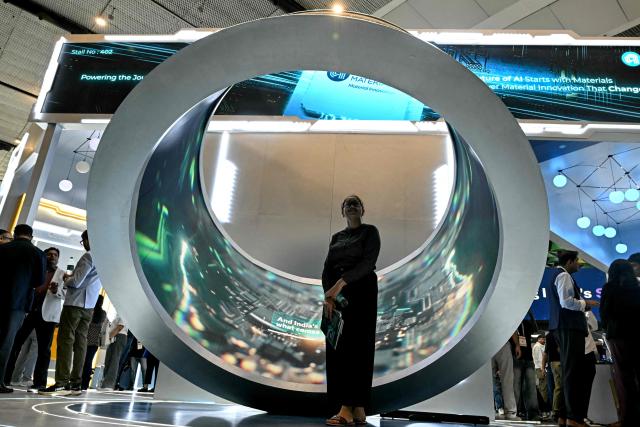 A visitor poses for a photograph with an installation displaying microprocessor chips during the SEMICON India 2026 Conference & Expo on the semiconductor and electronics ecosystem at Yashobhoomi Convention Centre in New Delhi on September 17, 2026. Prime Minister Narendra Modi pitched India as a new global hub for semiconductor production on September 17, urging technology firms to invest in what he called a "reliable" location. (Photo by Sajjad HUSSAIN / AFP)