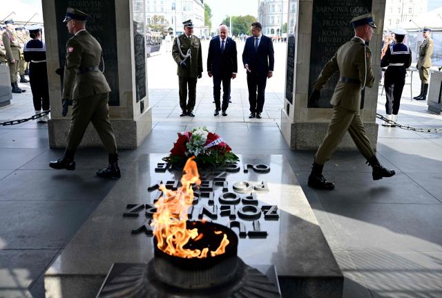 Austrian Chancellor Christian Stocker (C) takes part in a wreath-laying ceremony at the Tomb of the Unknown Soldier during his visit to Warsaw on September 17, 2026. (Photo by ROLAND SCHLAGER / APA / AFP) / Austria OUT