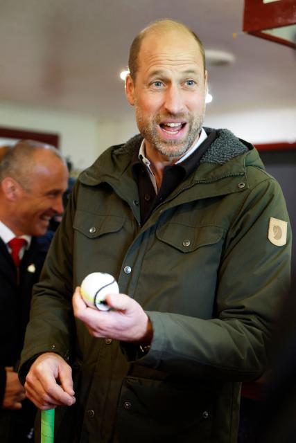 Britain's Prince William, Prince of Wales, meets representatives from the club's senior and youth teams, while visiting Bute Shinty Club in Rothesay, in the Isle of Bute, Scotland, on September 17, 2026. (Photo by Jeff J Mitchell / POOL / AFP)