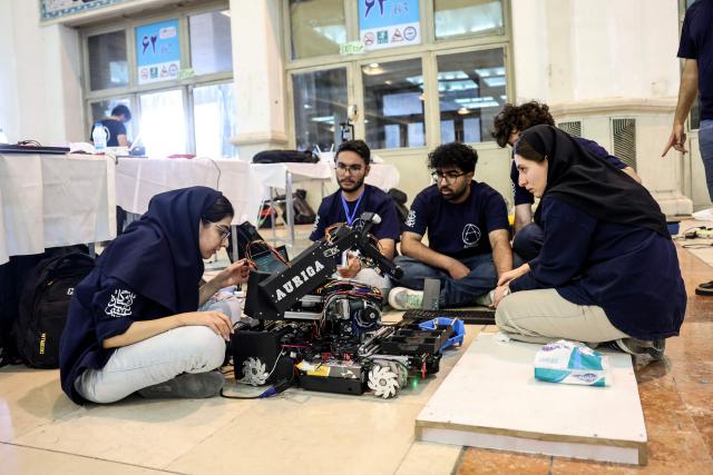 Iranian students work on their robot during the RoboCup IranOpen event at Tehran's Mosallah Mosque on September 17, 2026. (Photo by AFP)