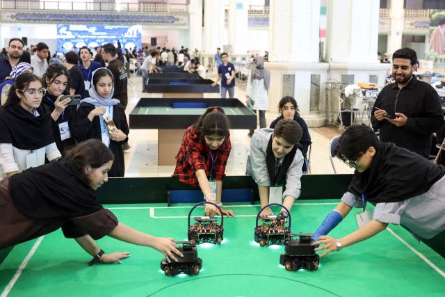 Iranian female students compete in a robotics challenge during the RoboCup IranOpen event at Tehran's Mosallah Mosque on September 17, 2026. (Photo by AFP)