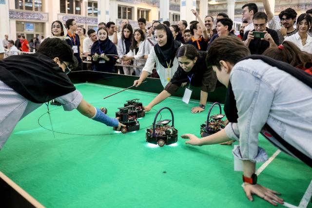 Iranian female students compete in a robotics challenge during the RoboCup IranOpen event at Tehran's Mosallah Mosque on September 17, 2026. (Photo by AFP)