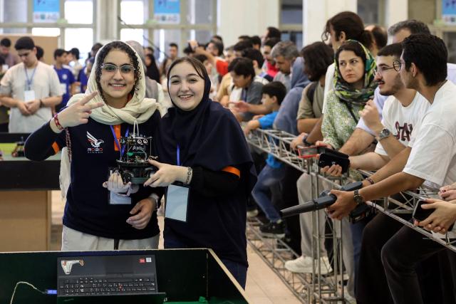 Iranian students pose with their robot during the RoboCup IranOpen event at Tehran's Mosallah Mosque on September 17, 2026. (Photo by AFP)