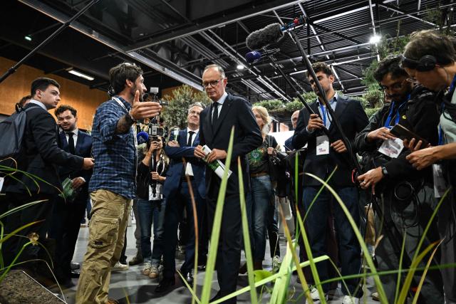 Right wing party Horizons candidate in France's 2027 presidential election Edouard Philippe (C), flanked by Mayor of Angers Christophe Bechu (C-L), listens to explanations as he visits the 'Salon du Vegetal' (plant fair) in Angers, western France on September 17, 2026. (Photo by Sebastien Salom-Gomis / AFP)