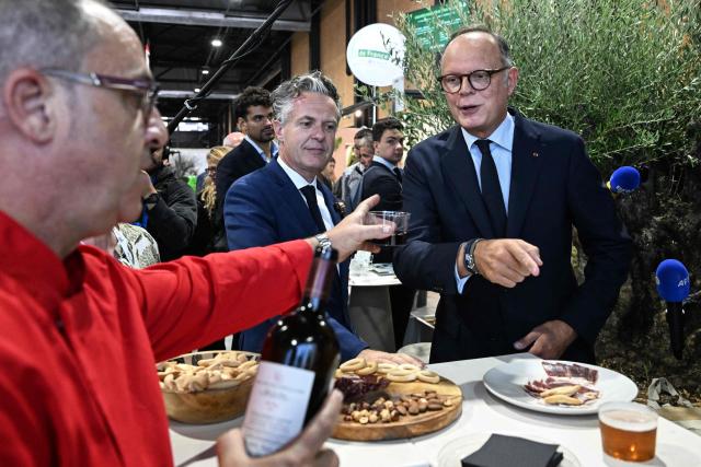 Right wing party Horizons candidate in France's 2027 presidential election Edouard Philippe (R), flanked by Mayor of Angers Christophe Bechu (C), tastes a drink as he visits the 'Salon du Vegetal' (plant fair) in Angers, western France on September 17, 2026. (Photo by Sebastien Salom-Gomis / AFP)
