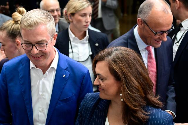 The conservative Christian Democratic Union (CDU) party's lead candidate for the Berlin state election, Stefan Evers and CDU federal treasurer Franziska Hoppermann react as German Chancellor Friedrich Merz looks on during a campaign event at the CDU headquarters in Berlin, on September 17, 2026. (Photo by John MACDOUGALL / AFP)