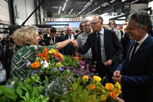 Right wing party Horizons candidate in France's 2027 presidential election Edouard Philippe (C) shakes hands as he visits the 'Salon du Vegetal' (plant fair) in Angers, western France on September 17, 2026. (Photo by Sebastien Salom-Gomis / AFP)