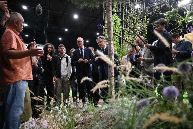 Right wing party Horizons candidate in France's 2027 presidential election Edouard Philippe (C-L), flanked by Mayor of Angers Christophe Bechu (C-R), listens to explanations as he visits the 'Salon du Vegetal' (plant fair) in Angers, western France on September 17, 2026. (Photo by Sebastien Salom-Gomis / AFP)
