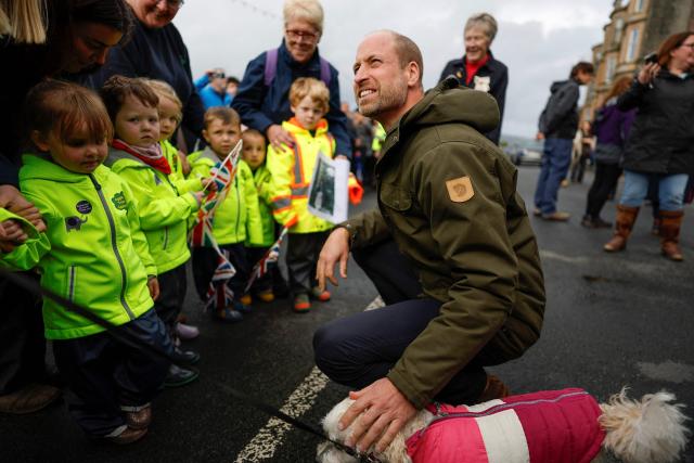 Britain's Prince William, Prince of Wales (R) meets young members of the public outside, after visiting the community-owned Anchor Tavern Pub & Hub in Port Bannatyne in the Isle of Bute, Scotland, September 17, 2026. (Photo by Jeff J Mitchell / POOL / AFP)