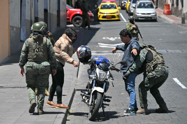 A soldier frisks a motorcyclist during a patrol in downtown Quito on September 17, 2026. Ecuador imposed a five-hour nighttime curfew in four coastal provinces affected by drug trafficking-related violence, authorities said, as part of efforts to intensify military and police operations from September 17 to 30, 2026. (Photo by Rodrigo BUENDIA / AFP)