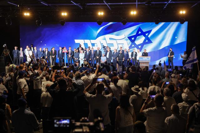 Israeli Prime Minister Benjamin Netanyahu (C) and his wife Sara stand on stage with Likud party lawmakers and members of the government during a Jewish New Year greetings event in Tel Aviv on September 17, 2026. Israel heads to the polls on October 27 in its first election since the October 7, 2023 Hamas-led attack, in what is seen as a referendum on the prime minister. (Photo by Jack GUEZ / AFP)