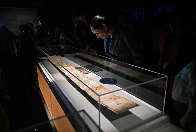 Mexico's Secretary of Culture, Claudia Curiel de Icaza, inspects part of the Boturini Codex, an ancient Aztec pictorial manuscript depicting the migration of the Mexica people from their mythical ancestral homeland of Aztlan, at the National Museum of Anthropology in Mexico City on September 17, 2026. A cherished 16th-century Mexican manuscript that tells the history of the Aztecs in pictograms goes on display on September 17 in Mexico City, nearly two centuries after it was whisked off to France. (Photo by Carl de Souza / AFP)