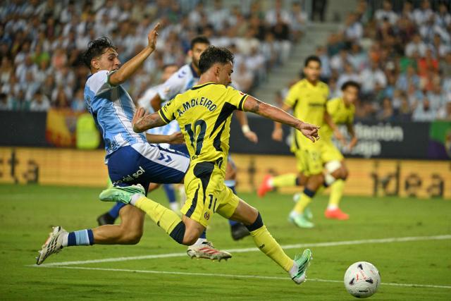Malaga's Spanish midfielder #23 Izan Merino fights for the ball with Villarreal's Spanish midfielder #10 Alberto Moleiro during the Spanish league football match between Malaga CF and Villarreal CF at La Rosaleda Stadium in Malaga on September 17, 2026. (Photo by JORGE GUERRERO / AFP)