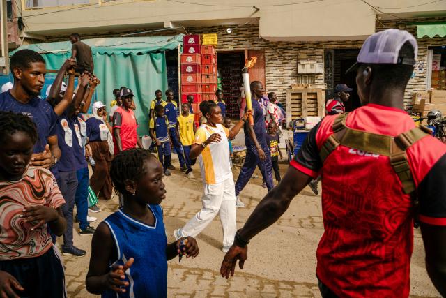 A torch bearer carries the Youth Olympic Flame during the flame's 46-day tour in Dakar on September 17, 2026. The Youth Olympic Flame will travel across Senegal's 14 regions before returning to Dakar for the opening ceremony on October 31, 2026. Senegal will host the Summer Youth Olympic Games from October 31 to November 13, 2026, bringing together 2,700 athletes competing in 25 sports. (Photo by Carmen Abd Ali / AFP)