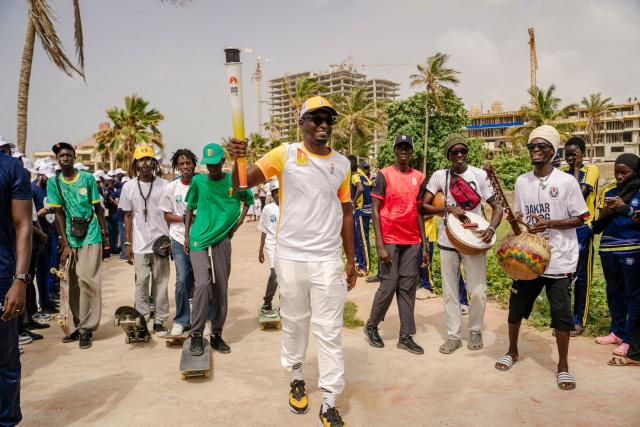A torch bearer carries the Youth Olympic Flame during the flame's 46-day tour in Dakar on September 17, 2026. The Youth Olympic Flame will travel across Senegal's 14 regions before returning to Dakar for the opening ceremony on October 31, 2026. Senegal will host the Summer Youth Olympic Games from October 31 to November 13, 2026, bringing together 2,700 athletes competing in 25 sports. (Photo by Carmen Abd Ali / AFP)