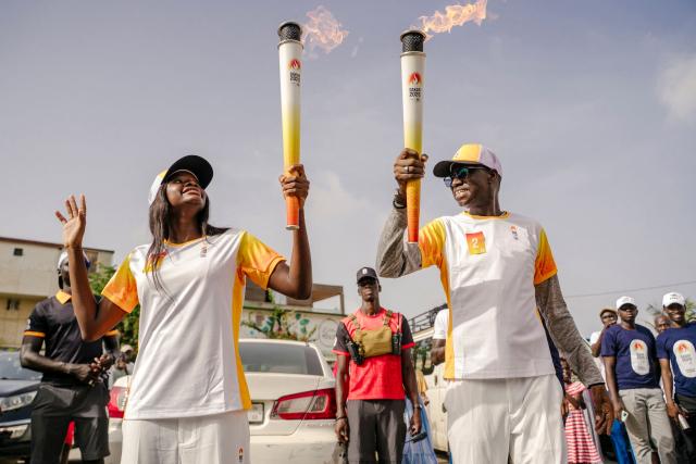 Torch bearers carry the Youth Olympic Flame during the flame's 46-day tour in Dakar on September 17, 2026. The Youth Olympic Flame will travel across Senegal's 14 regions before returning to Dakar for the opening ceremony on October 31, 2026. Senegal will host the Summer Youth Olympic Games from October 31 to November 13, 2026, bringing together 2,700 athletes competing in 25 sports. (Photo by Carmen Abd Ali / AFP)