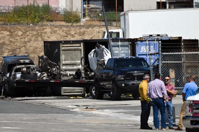 A worker loads wreckage onto a flat bed as investigators work at the scene of an NBC4 TV news helicopter that crashed in Chatsworth neighborhood of Los Angeles, California, on September 17, 2026. Three people were killed September 15 in a fiery crash when a US news helicopter covering a deadly bus accident came down in a Los Angeles neighborhood. Media in the city had scrambled to cover an incident in which an SUV ploughed into a bus in the Chatsworth area, northwest of downtown, killing three people and injuring many others. Reporters who were at the scene of the bus crash said they heard a loud bang, with some saying they saw a helicopter come down around a block away, sending plumes of smoke into the air. (Photo by Patrick T. Fallon / AFP)