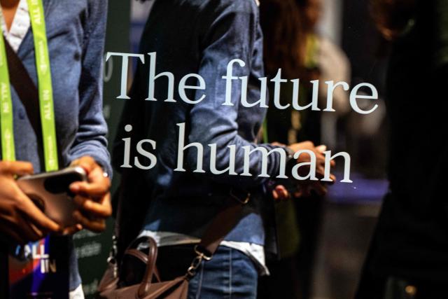 The motto “The future is human”, used prominently by "The Be Human Company", a Canadian AI strategy and transformation company, is seen during day two of the "ALL IN 2026" conference at the Palais des Congres de Montreal in Montreal, Quebec, Canada, on September 17, 2026. "ALL IN" is Canada's largest artificial intelligence and technology event. (Photo by ANDREJ IVANOV / AFP)