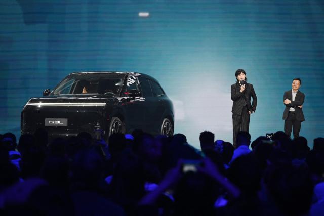 He Xiaopeng, Chairman and CEO of Chinese car maker XPeng (R) appears on stage with actor Yin Zheng at the launch of the XPeng G9L SUV in Beijing on September 17, 2026. The car, which comes in pure electric and hybrid variants, will be produced in factories in Guangzhou, in southern China, and Graz, Austria. (Photo by GREG BAKER / AFP)
