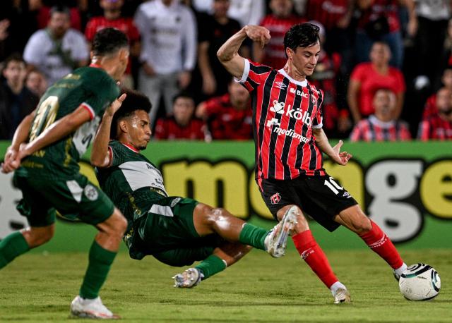 Marathon's defender #14 Javier Arriaga and Alajuelense's Venezuelan midfielder #10 Juanpi fight for the ball during the second-leg quarterfinal football match of the Concacaf Central American Cup between Costa Rica's LD Alajuelense and Honduras' CD Marathon at the Alejandro Morera Soto Stadium in Alajuela, Costa Rica, on September 17, 2026. (Photo by Ezequiel BECERRA / AFP)