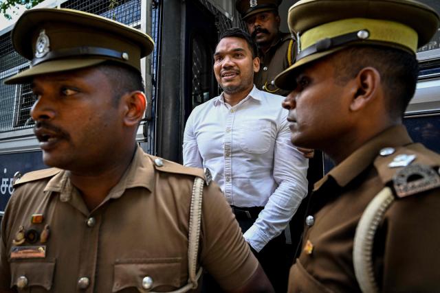 Prison officers escort Sri Lanka's Member of Parliament Namal Rajapaksa (C) to appear before a magistrate at a court in Colombo on September 18, 2026. The opposition lawmaker Rajapaksa is being investigated over allegations linked to a 2013 Airbus aircraft deal signed during his father's presidency. (Photo by Ishara S. KODIKARA / AFP)