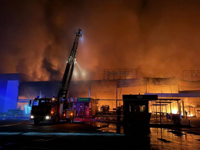 Firefighters work to push out a fire in a mall following a drone strike in  Zaporizhzhia, late on September 17, 2026, amid the Russian invasion of Ukraine. (Photo by Darya NAZAROVA / AFP)