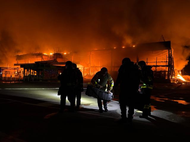 Firefighters work to push out a fire in a mall following a drone strike in  Zaporizhzhia, late on September 17, 2026, amid the Russian invasion of Ukraine. (Photo by Darya NAZAROVA / AFP)