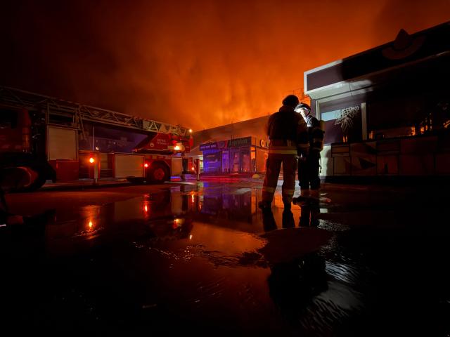Firefighters work to push out a fire in a mall following a drone strike in  Zaporizhzhia, late on September 17, 2026, amid the Russian invasion of Ukraine. (Photo by Darya NAZAROVA / AFP)