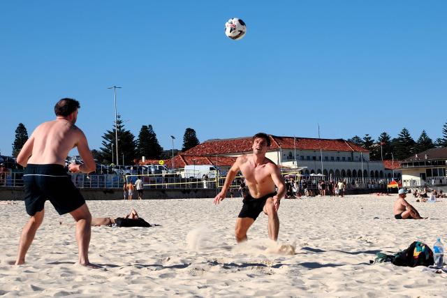 People spend their afternoon on a sunny day on Bondi Beach in Sydney on September 18, 2026. Australia will detain tourists who overstay visas to send a message of deterrence under new rules aimed at reducing levels of migration, a minister said on September 18. (Photo by Xiaoyu Yin / AFP)