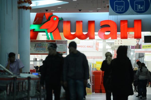 (FILES) Customers walk near an entrance of an Auchan Hypermarket  in Moscow,  on October 22, 2012. Russian authorities have seized the businesses and assets of Swiss food giant Nestle and three French groups, a move the Kremlin defended on September 18, 2026 as a justified measure against firms representing "unfriendly countries" that back Ukraine. A decree signed by President Vladimir Putin transferred the Russian operations of Nestle, French retailer Auchan and the former Leroy Merlin DIY chain, now known as Lemana Pro, to a company called LEV Management. (Photo by NATALIA KOLESNIKOVA / AFP)