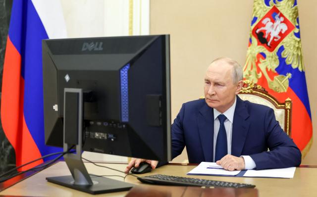 In this pool photograph distributed by the Russian state agency Sputnik, Russia's President Vladimir Putin votes online in the parliamentary election in Moscow on September 18, 2026. (Photo by Vyacheslav PROKOFYEV / POOL / AFP)