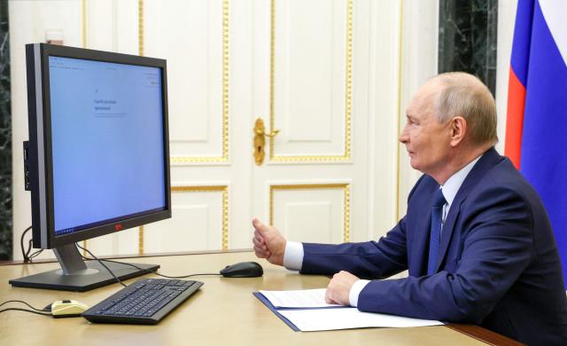 In this pool photograph distributed by the Russian state agency Sputnik, Russia's President Vladimir Putin votes online in the parliamentary election in Moscow on September 18, 2026. (Photo by Vyacheslav PROKOFYEV / POOL / AFP)