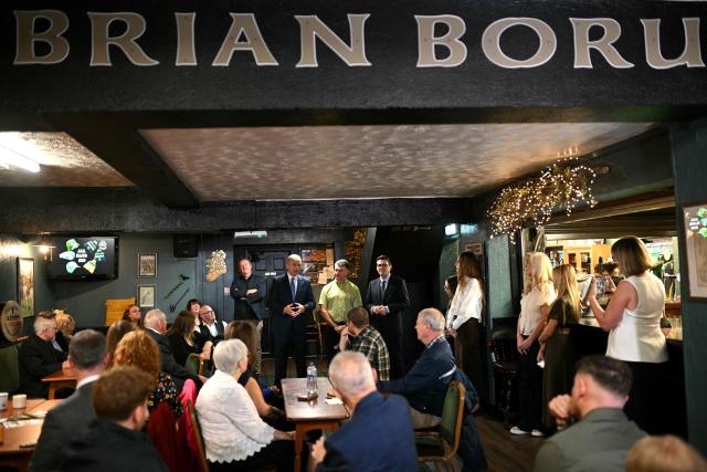 Britain's Prime Minister Andy Burnham and Ireland's Prime Minister Micheal Martin react visit to the Brian Boru Irish Club in, Ashton-in-Makerfield, northern England, on September 18, 2026. (Photo by Oli SCARFF / POOL / AFP)