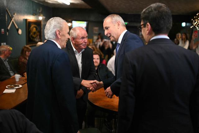 Britain's Prime Minister Andy Burnham and Ireland's Prime Minister Micheal Martin are greeted by members of the local community during a visit to the Brian Boru Irish Club in, Ashton-in-Makerfield, northern England, on September 18, 2026. (Photo by Oli SCARFF / POOL / AFP)
