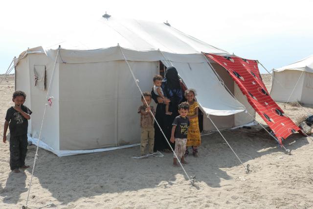 Internally displaced people (IDPs) are seen outside their tent at Al-Farsi displacement camp in Ras Imran on the outskirts of Al-Buraiqah district in southwest Aden in southern Yemen on September 17, 2026. The fighting in Yemen in recent weeks has displaced nearly 86,000 people, a UN agency said on September 13, with the number surging by 10,000 from a day earlier. (Photo by Mohamad Hakim / AFP) / 
